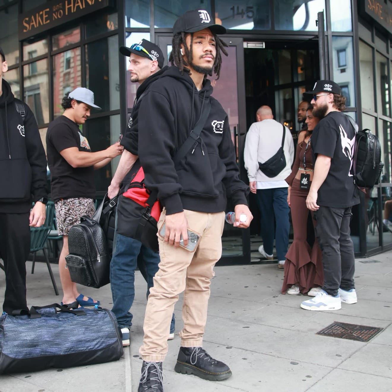 Corn (@CornKry) standing with a group outside a restaurant